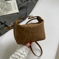 Chic brown leopard embossed bag with gold clasp shown on a grey blazer model - Brown