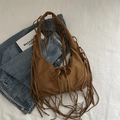 Caramel brown suede shoulder bag featuring long bohemian tassels and a drawstring closure - Brown