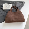 Minimalist dark brown suede tote bag with wide shoulder strap on a grey blazer - Brown