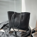 Minimalistische schwarze matte Leder-Shopper mit Schultergurten in natürlichem Licht - Schwarz