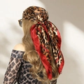 Foulard quadrato in satin leopardato con bordi rossi indossato come copricapo - Leopardo Rosso
