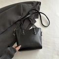 Minimalist black leather bucket bag with gold hardware and fashion lettering detail - Black