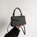 Minimalist black crossbody bag with knotted handle and elegant envelope flap design - Black