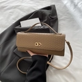 Sac bandoulière carré marron tressé avec fermoir doré sur fond de veste de costume grise - Kaki