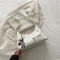 Borsa a mezzaluna in finta pelle bianca con ciondolo a fumetti e cerniera anteriore - Bianco