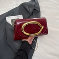 Burgunderrote Lackledertasche mit goldener Oval-Schnalle und glänzender Oberfläche - Rot