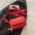 Rote Satteltasche mit breitem Gurt und goldenen Beschlägen auf grauem Sakko - Rot