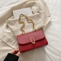 Minimalist red leather crossbody bag with gold chain strap and oval metal buckle - Red