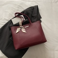 Chic burgundy leather tote bag with silk scarf accessory and minimalist metal detail - Red
