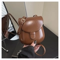 Borsa a tracolla in pelle PU marrone con patta a semicerchio e fibbia dorata tenuta in mano - Marrone