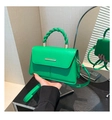 Dettaglio della borsa verde con manico intrecciato e chiusura in metallo oro - Verde