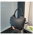 Detalle de bolso cubo negro con asa trenzada cilíndrica y herrajes de metal plateado - Negro
