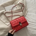 Rode gewatteerde crossbodytas met zilveren ketting en vierkant slot op een beige blazer - Rood