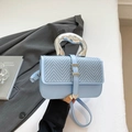 Light blue crossbody bag with woven texture lid and silver metallic handle detail - Blue