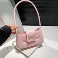 Rosa Schultertasche aus Kunstleder mit goldener Schleife aus einer stylischen Perspektive - Rosa