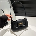 Schicke schwarze Baguette-Tasche mit goldener Schleife auf minimalistischem Hintergrund - Schwarz