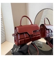 Close-up of deep red quilted handbag with chocolate square texture and glossy finish - Red