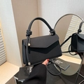 Chic black striped textured handbag with knot handle and gold hardware in mirror view - Black