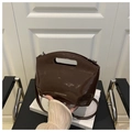 Detail of dark brown patent leather bucket bag with hollow handle and shoulder strap - Brown