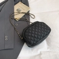 Borsa a tracolla trapuntata nera con catena dorata regolabile su un blazer grigio - Nero