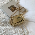 Dettaglio elegante borsa a mano dorata lucida con tracolla a catena e finitura a specchio - Oro champagne