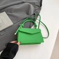 Grass green woven crossbody bag featuring unique triangular flap and knotted handle detail - Green