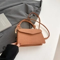 Brown woven texture crossbody bag with knot shoulder strap on gray blazer background - Dark Brown