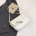 White faux leather crossbody bag featuring a unique oversized silver safety pin buckle - White