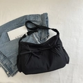 Black pleated tote bag with twin bows and wide crossbody strap on white background - Black