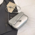 Sleek silver crossbody bag with metallic chain buckle and thin leather strap for women - Silver