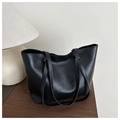 Close-up of black leather tote bag featuring printed text and secure zipper details - Black