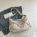 Light beige pleated tote bag with bow details on denim background for daily use - Khaki