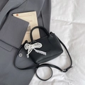 Elegant black lychee leather bucket bag with pearl lace bow charm on white background - Black With Pendant