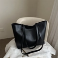 Retro black leather tote bag with embossed text on a white chair for daily commute - Black