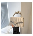Detalle de bolso acolchado beige con asa plisada y textura de costuras en forma de V - Caqui