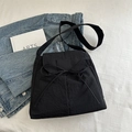 Black nylon crossbody tote bag featuring a decorative bow tie and long shoulder strap - Black
