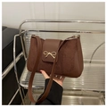 Detail der dunkelbraunen Baguette-Tasche mit mattem Wildleder und goldener Schleife - Braun