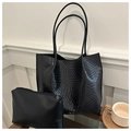 Detalle de la textura de cuero trenzado negro del bolso tote con neceser interior - Negro