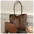 Detalle de bolso tote trenzado marrón con neceser a juego en un estante de madera natural - Marrón
