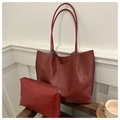Detalle del bolso tote tejido rojo oscuro con neceser con cremallera a juego sobre madera - Rojo