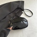 Sac bandoulière ovale noir brillant avec fermetures éclair dorées chic - Noir