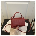Close-up of red crocodile pattern mini crossbody bag with top handle and PU leather texture - Red