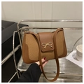 Detalle del bolso de hombro marrón vintage con una elegante hebilla de lazo dorado - Marrón