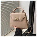 Détail d'un sac à main beige trapèze avec fermoir pivotant doré et texture en cuir lisse - Kaki