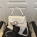 Elegante cremeweiße strukturierte Handtasche mit silberner G-Schnalle und Griff auf schwarzem Leder - Weiß