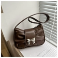Detail of matte brown leather shoulder bag featuring a unique bow-shaped fold and silver buckle - Brown