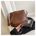 Dettaglio della borsa a sella marrone vintage con texture in finta pelle e tracolla - Marrone