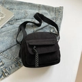 Black corduroy crossbody bag with woven zipper detail and adjustable nylon shoulder strap - Black