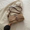 Brown vintage baguette shoulder bag with gold metal buckle on a beige blazer - Khaki