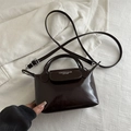 Mini donkerbruine glanzende crossbodytas in dumpling-stijl met rond handvat - Donkerbruin